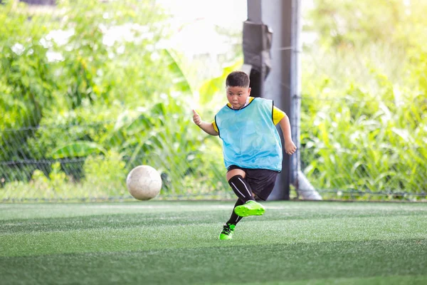 kid soccer player speed run to shoot ball to goal on artificial