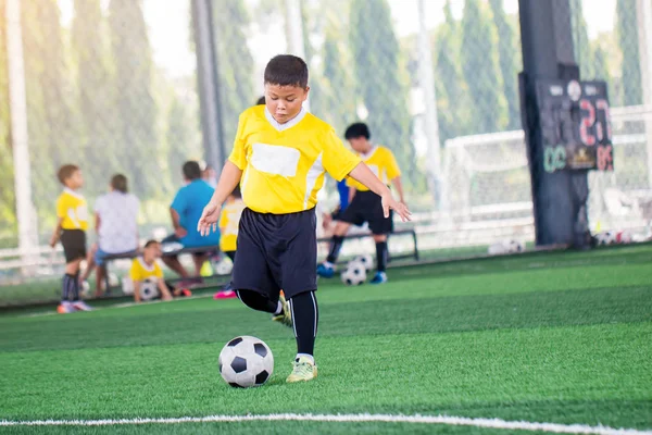 blurry ball with Asian kid soccer player speed run to shoot ball