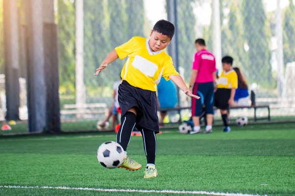 Palla sfocata con Asiatico bambino giocatore di calcio velocità correre a sparare palla — Foto Stock