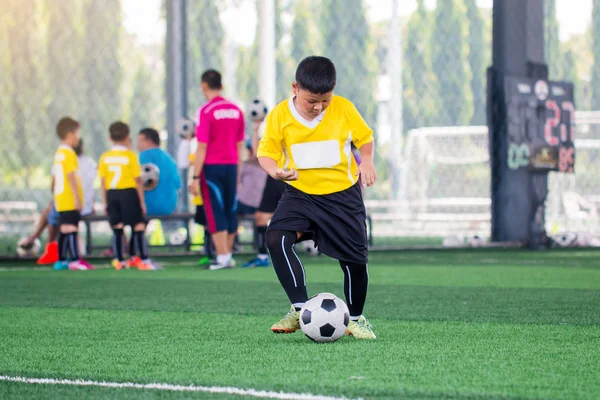 Palla sfocata con Asiatico bambino giocatore di calcio velocità correre a sparare palla — Foto Stock