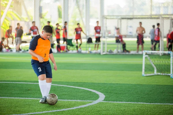 アジアの少年サッカー選手スピードは、アーティフでゴールにボールを撃つために実行します — ストック写真