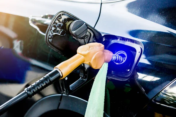 Recarga a mano del coche negro con combustible en la gasolinera. aceite a — Foto de Stock