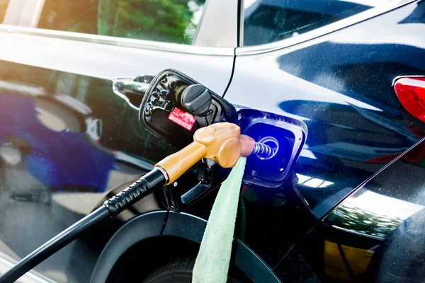 Hand das schwarze Auto an der Tankstelle mit Kraftstoff betankt. Öl a — Stockfoto