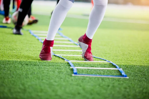 Joueur de football jogging et saut entre le marqueur pour le train de football — Photo