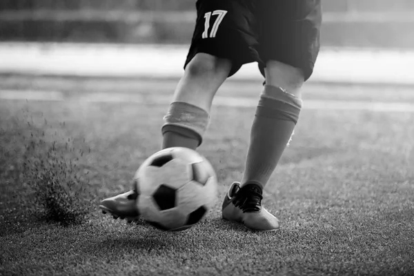 Imagem preto e branco de bola embaçada após menino jogador de futebol spe — Fotografia de Stock