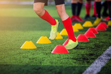 Futbolcu koşu ve yeşil sanat koni işaretçileri arasındaki atlama