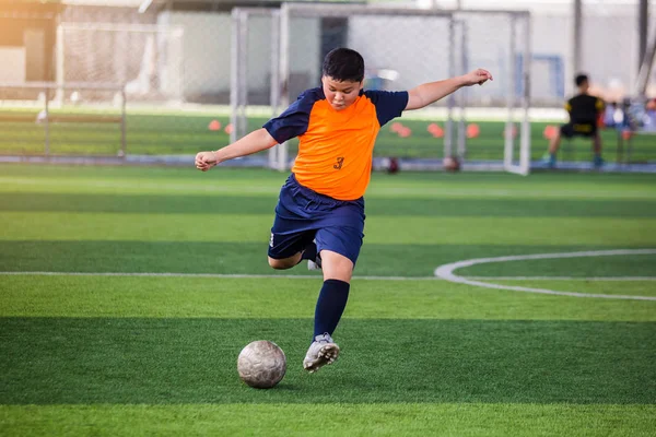 Soccer player speed run to shoot ball to goal on artificial turf