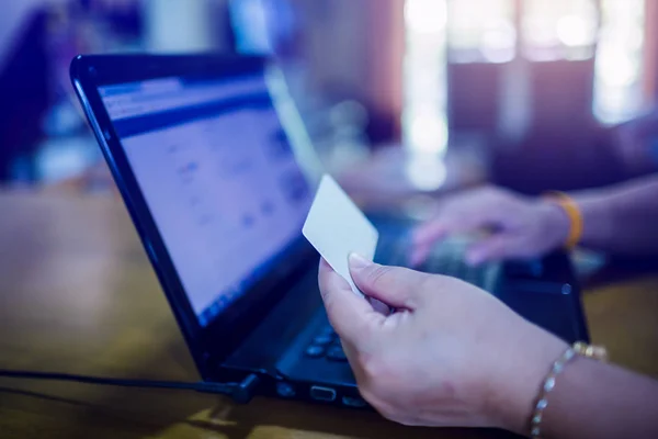 Manos con tarjeta de crédito de plástico y el uso de ordenador portátil. Compras en línea — Foto de Stock