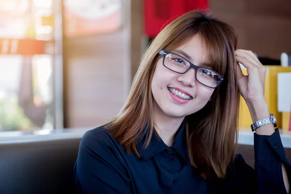 Счастливая улыбка азиатской молодой женщины в зубных скобках и очках — стоковое фото