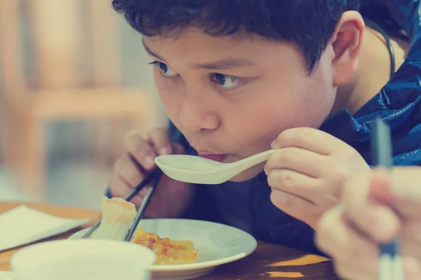 Хлопчик їсть китайську їжу. — стокове фото