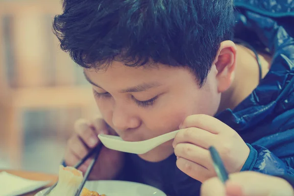 Il ragazzo sta mangiando cibo cinese . — Foto Stock
