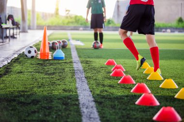 Futbolcu koşu ve yeşil sanat koni işaretçileri arasındaki atlama