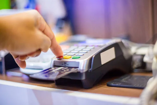 Рука положить кредитную карту в слот и нажать на кнопку кредитной карты — стоковое фото