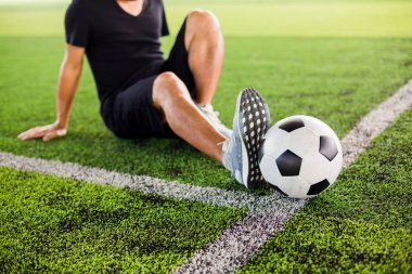 Oyuncu ile yeşil suni çim üzerinde Futbol topu germek olduğunu 