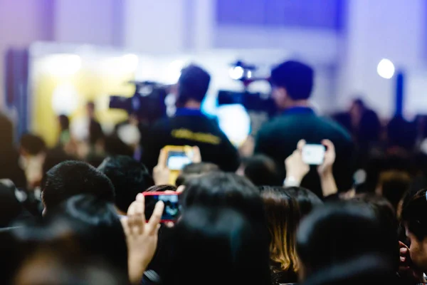 blurry image of business people and cameraman with video camera