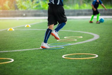 çocuk futbolcu Jogging için seçici odak ve ring la atlamak