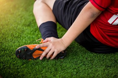 futbolcu oturuyor ve ayak bileği yakalamak nedeniyle