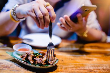 Kadın akıllı telefon oynarken birlikte yiyor. Toda yaşam tarzı