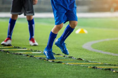 Çocuk futbolcu Jogging ve futbol t için marker arasında atlamak