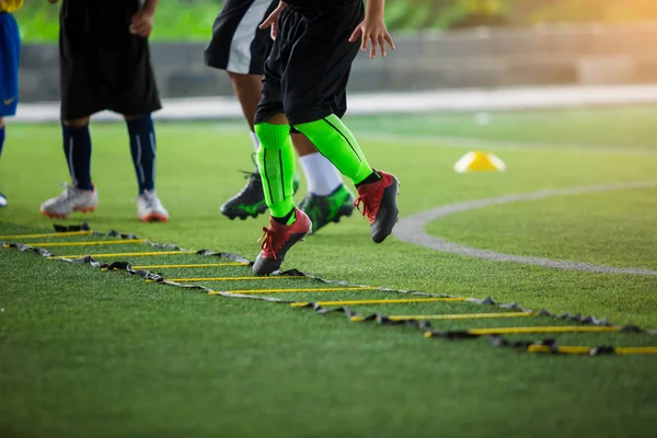 Anak pemain sepak bola jogging dan melompat antara penanda untuk sepak bola t — Stok Foto