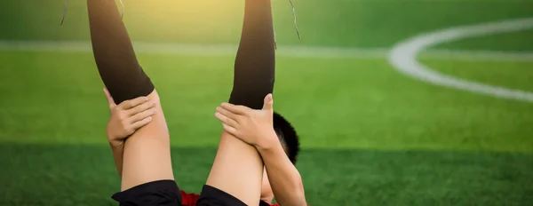 Chłopiec piłkarz Rozciągnij mięśnie z leżąc z powrotem przed rozpoczęciem f — Zdjęcie stockowe
