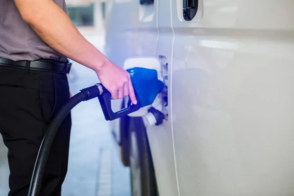 Riempire a mano il furgone bianco di carburante alla stazione di servizio. Olio a — Foto Stock