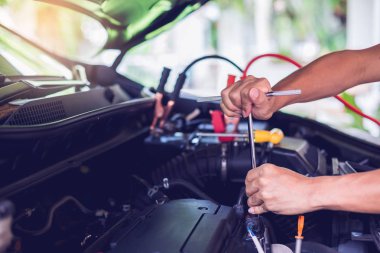 Araba tamircisi bir İngiliz anahtarı motor ve m kontrol etmek hazır tutuyor