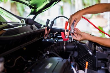 Bir erkek mekanik engi kontrol etmek için bir atölyede tornavida kullanın