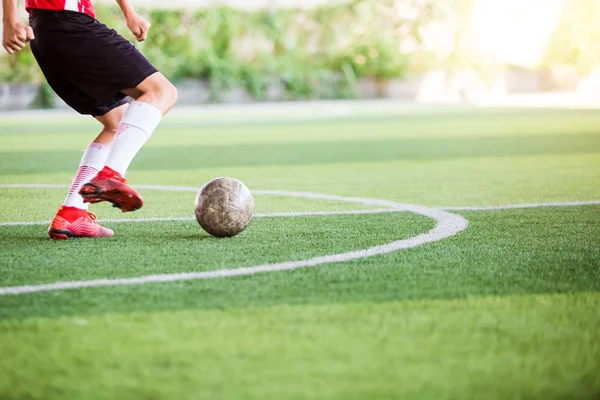 Soccer player speed run on green artificial turf to shoot ball t