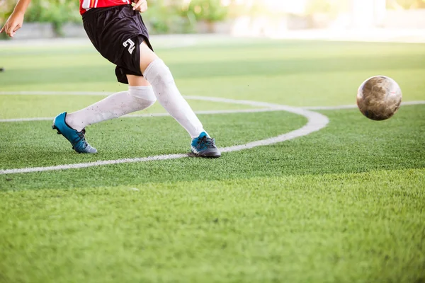 Soccer player speed run on green artificial turf to shoot ball t