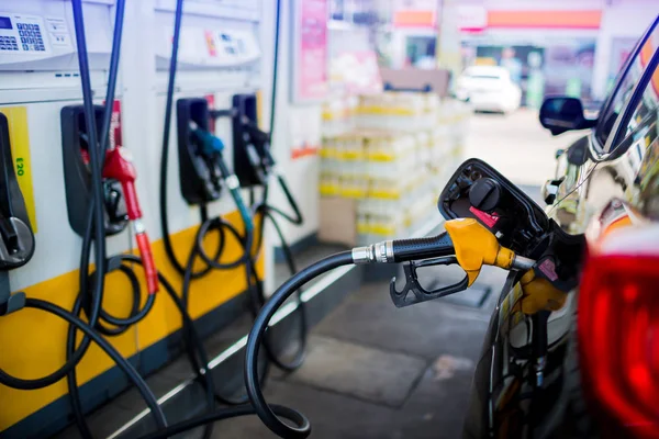 De auto bijvullen met brandstof bij het benzinestation en wazig personeel — Stockfoto