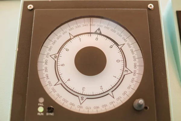 Compass in control room on international cargo ship in the ocean