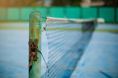 Bulanık yeşil arka plan ile eski tenis net seçici odak. 