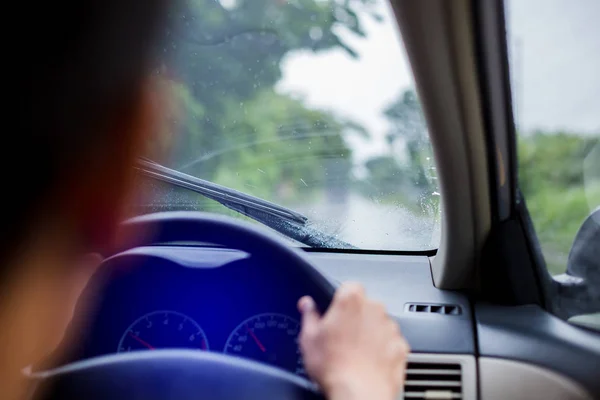 Selektywny nacisk na człowieka jazdy samochodem z kropli deszczu na windsh — Zdjęcie stockowe