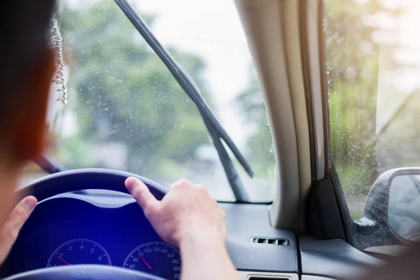 Focus sélectif sur l'homme conduisant une voiture avec des gouttelettes de pluie sur le vent — Photo