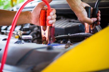 seçici odak elleri elektrikli sarı araba aküsü şarj yapmak