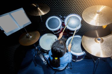 Bulanık davul seti ve Asyalı kız öğrenme ve ahşap ile oynamak 