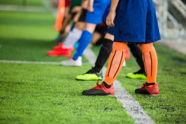 Çocuk futbolcular yeşil yapay beyaz çizgi üzerinde duran 