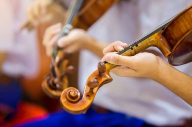 Asyalı erkek öğrenciler gro müzik gösterimi ile keman çalıyor