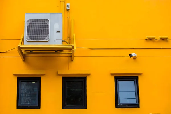 Air conditioning compressor with black glass windows on the yell