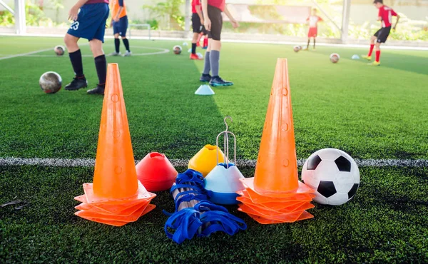 Bola de futebol e cone marcador com equipamento de treinamento em arte verde — Fotografia de Stock