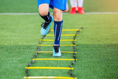 Çocuk futbolcu Jogging ve futbol t için marker arasında atlamak