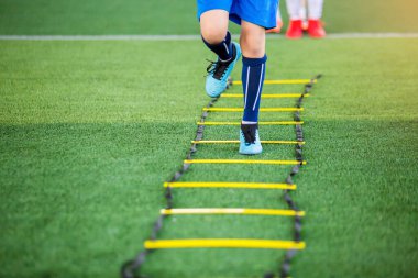Çocuk futbolcu Jogging ve futbol t için marker arasında atlamak