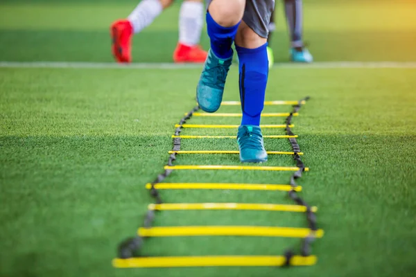 Dětský fotbalista joggingu a skok mezi značkou pro fotbal — Stock fotografie