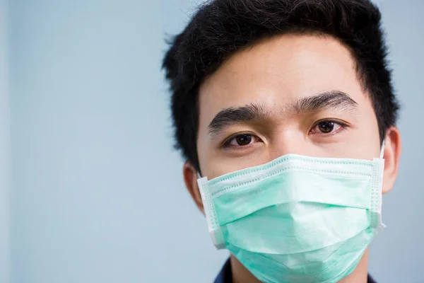 Asian man wears a face mask that protects against the spread of coronavirus disease. Close- up of a young woman with a surgical mask on her face against Covid-19.