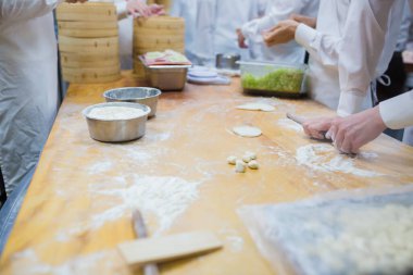 Aşçılar Çin mantılarını geleneksel bambu buharlı tencerelerle bir restoranda pişiriyorlar. Dim Sum şefleri Tayvan 'daki ünlü restoranda hamur işi paketliyor..