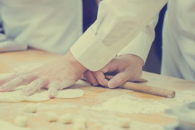 Aşçılar Çin mantılarını geleneksel bambu buharlı tencerelerle bir restoranda pişiriyorlar. Dim Sum şefleri Tayvan 'daki ünlü restoranda hamur işi paketliyor..