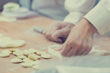 Aşçılar Çin mantılarını geleneksel bambu buharlı tencerelerle bir restoranda pişiriyorlar. Dim Sum şefleri Tayvan 'daki ünlü restoranda hamur işi paketliyor..