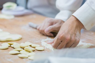 Aşçılar Çin mantılarını geleneksel bambu buharlı tencerelerle bir restoranda pişiriyorlar. Dim Sum şefleri Tayvan 'daki ünlü restoranda hamur işi paketliyor..