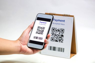 Beyaz arka planda QR kod ödemesini taramak için akıllı telefonu tutuyorum. Nakitsiz teknoloji ya da dijital ödeme kavramı.